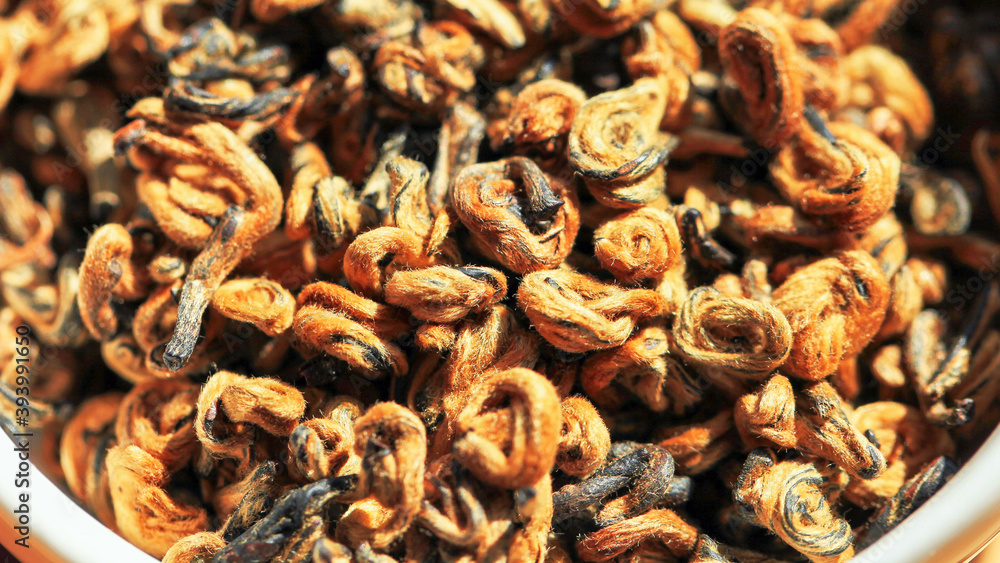 Chinese red tea Golden Curls (Dianhong Jin Luo) high quality with red furry tea buds. Macro image with blurred background. Chinese red tea Golden Curls (Dianhong Jin Luo) high quality with red furry tea buds. Macro image with blurred background.