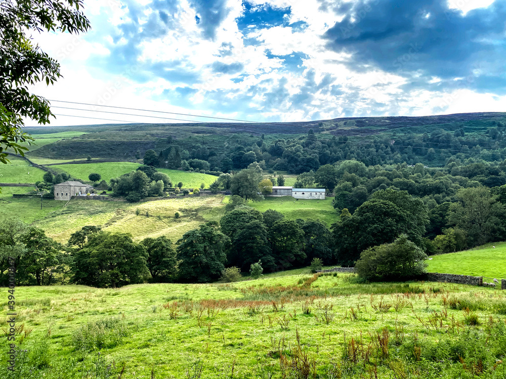 Obraz premium Landscape view from, Hey's Lane, with sloping fields, farms, meadows, and trees in the distance in, Wainstalls, Halifax, UK
