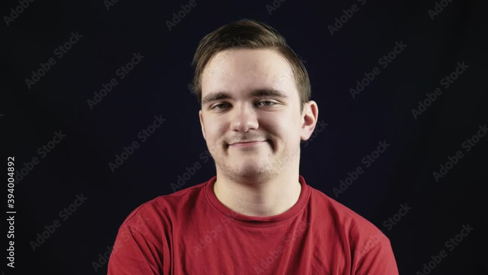 Young handsome man in casual t-shirt standing against isolated dark background, indignant and pensive with frowning face Young handsome man in casual t-shirt standing against isolated dark background, indignant and pensive with frowning face