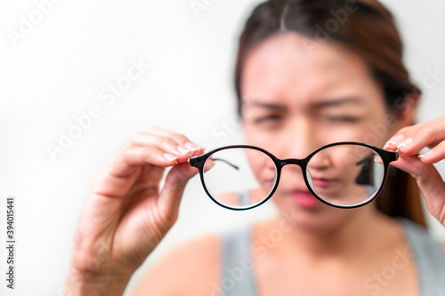 Asian woman holding glasses on white background, Selective focus on glasses , myopia and eyesight problem concept. photo