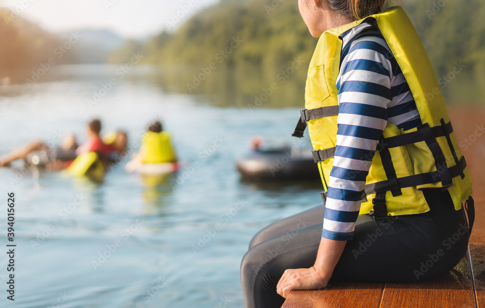 Asian woman wear life jacket sit near river, selective focus, with copy  space. Stock Photo | Adobe Stock