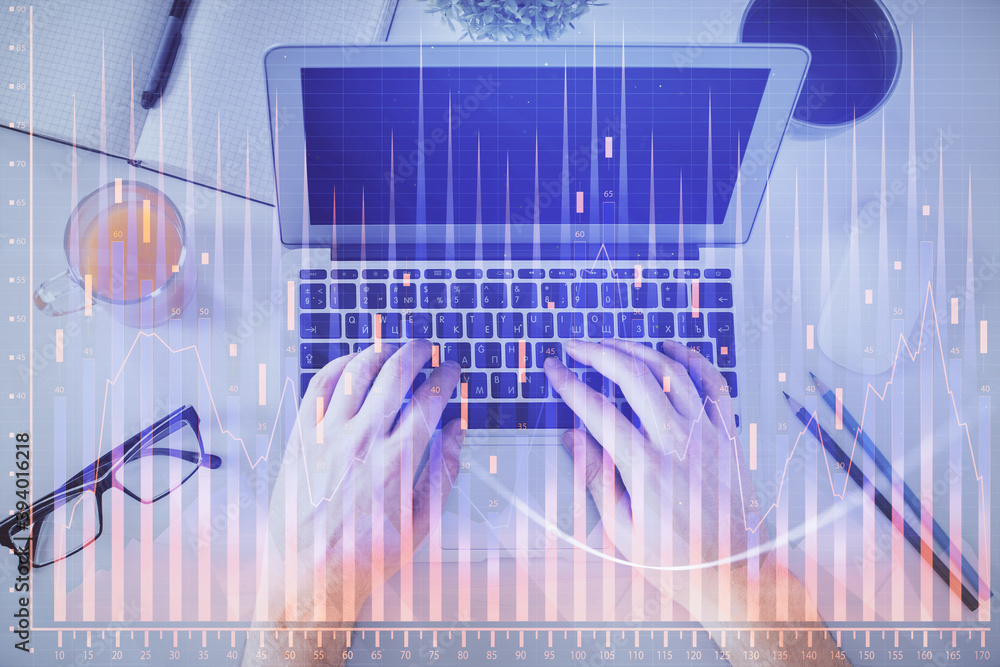 Double exposure of man's hands typing over laptop keyboard and forex chart hologram drawing. Top view. Financial markets concept. Double exposure of man's hands typing over laptop keyboard and forex chart hologram drawing. Top view. Financial markets concept.