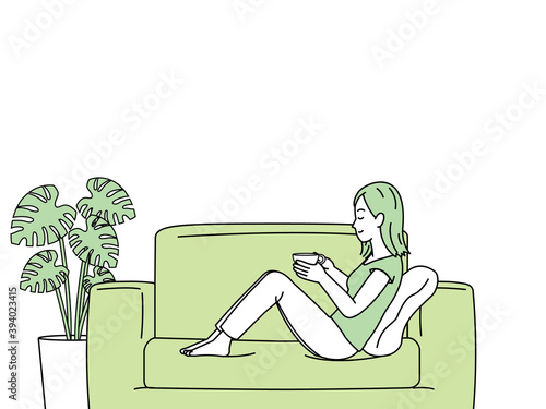 ソファーに座ってお茶を飲む女性　リラックス