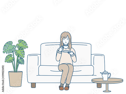 ソファーに座ってお茶を飲む女性　リラックス