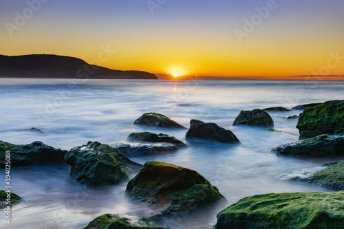 Sunrise by the Sea and Rocks on the Shoreline