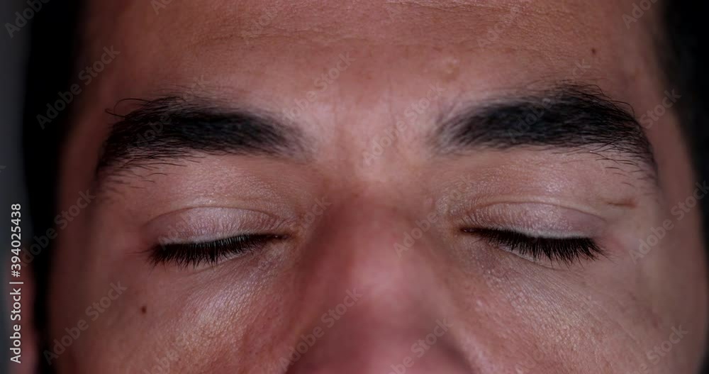 Man closing eyes in meditation. Contemplative person opening eyes smiling, macro face close-up Man closing eyes in meditation. Contemplative person opening eyes smiling, macro face close-up