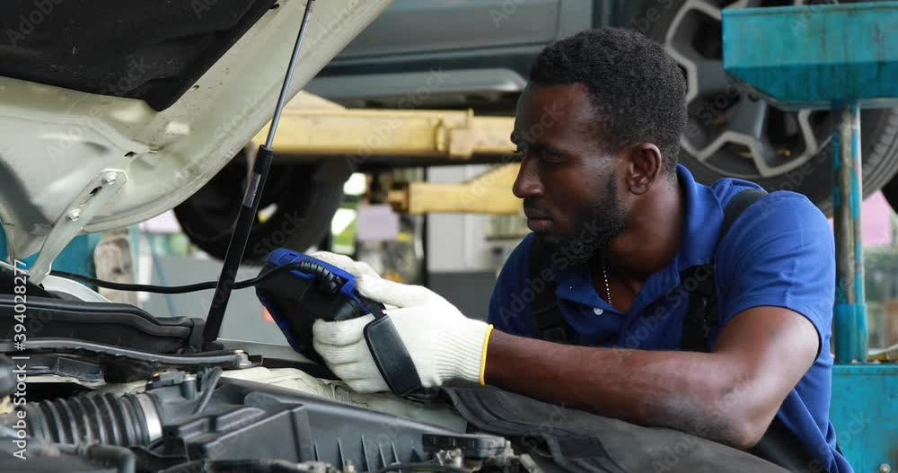 Professional car mechanic repair service and checking car engine by Diagnostics Software computer. Expertise mechanic working in automobile repair garage. Professional car mechanic repair service and checking car engine by Diagnostics Software computer. Expertise mechanic working in automobile repair garage.