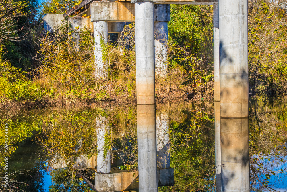 Fototapeta premium Bridge columns reflection in a calm river in the Fall
