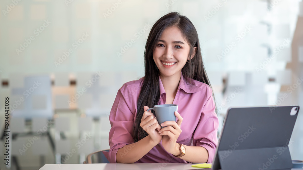 Young asian business woman beautiful charming smiling and drinking coffee in office. Looking at camera. Young asian business woman beautiful charming smiling and drinking coffee in office. Looking at camera.