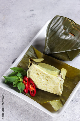 Delicious traditional Indonesian culinary, Tum Ayam or gadon ayam or botok, steamed minced chicken mix with herb spices and wrapped with banana leaf. photo