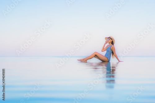 Portrait beautiful young asian woman relax smile leisure around outdoor swimming pool nearly sea