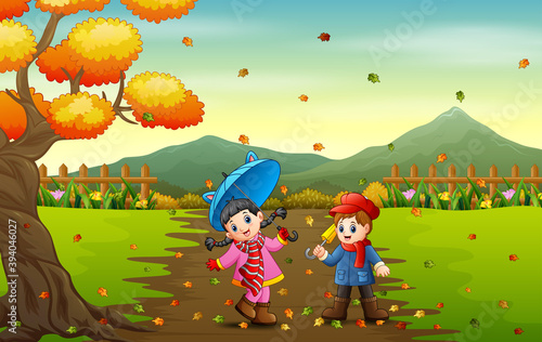 Children playing with autumn fallen leaves in park