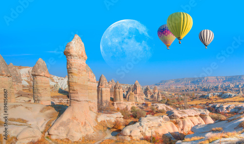 Hot air balloon flying over spectacular love valley of Cappadocia with full moon - Goreme, Turkey "Elements of this image furnished by NASA "