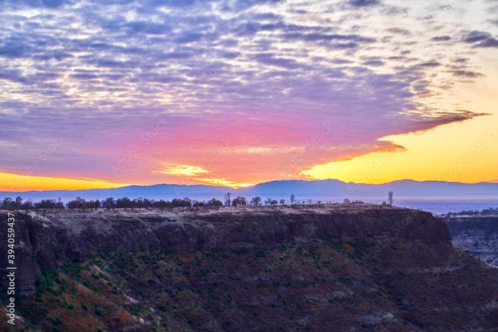 Sunset in California Mountains with orange skies and white and blue skies. Lookout Point Paradise California.   