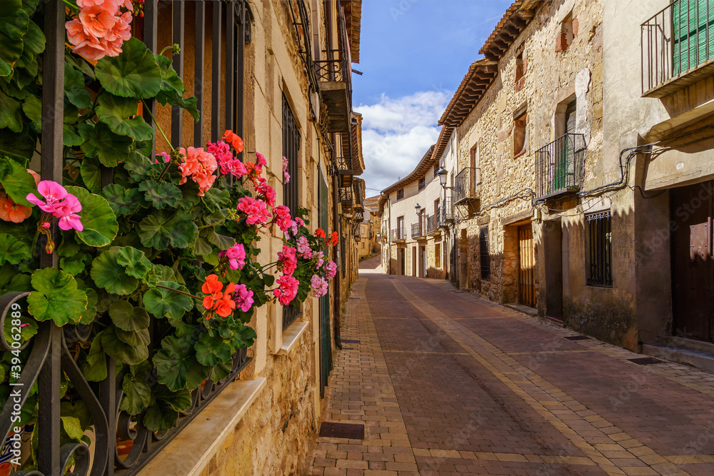 Fototapeta premium Flores en las ventanas en la vieja ciudad medieval de Atienza Guadalajara con casas y calles de piedra. 
