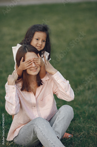 Beautiful family in a park. Woman in a blouse. Mother with daughter.