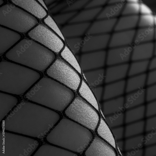Female legs wearing fishnet stockings, fetish concept. monochrome © beauty_objects