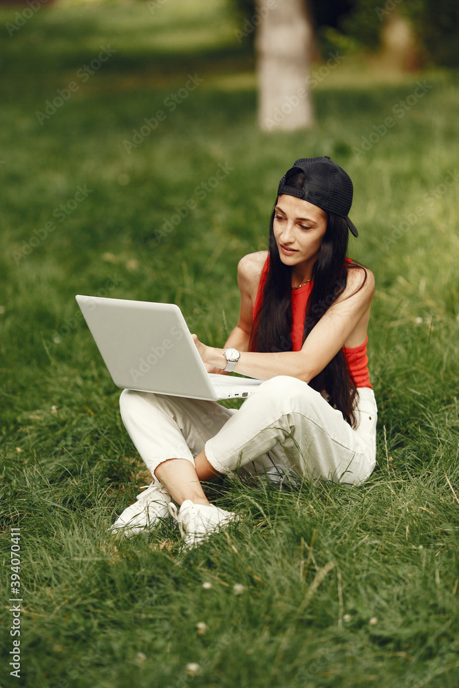 Woman in a spring city. Lady with a laptop. Girl sitting on a grass. Woman in a spring city. Lady with a laptop. Girl sitting on a grass.