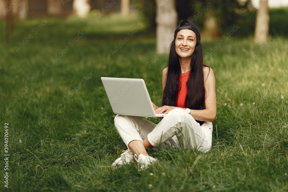 Woman in a spring city. Lady with a laptop. Girl sitting on a grass. Woman in a spring city. Lady with a laptop. Girl sitting on a grass.