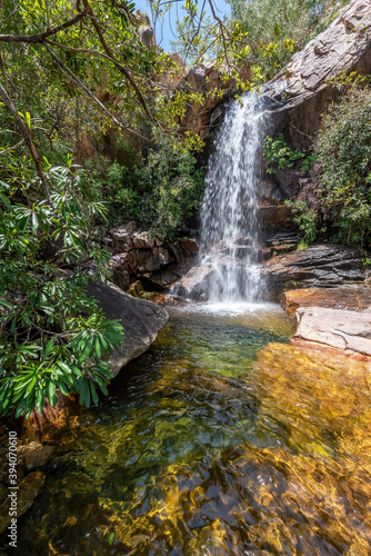 Cascading water at Boulder Creek with lush bushland greenery and fallen trees in the tropical Northern Territory at the top end of Australia.