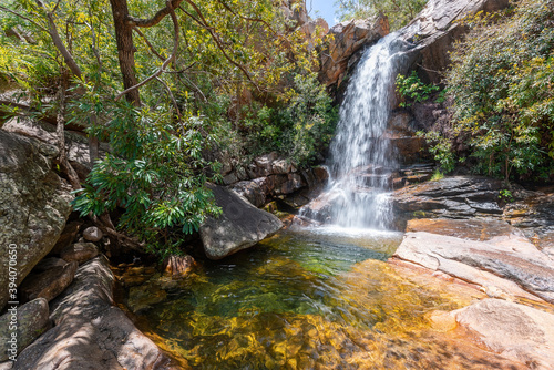 Cascading water at Boulder Creek with lush bushland greenery and fallen trees in the tropical Northern Territory at the top end of Australia.