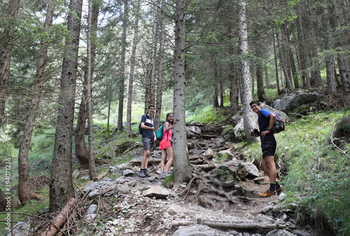 Фотография two brothers and a sister walking in the path in the middle of t