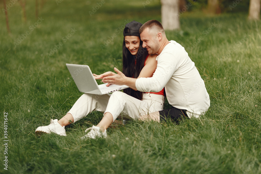 Couple in a spring city. Lady with a laptop. People sitting on a grass. Couple in a spring city. Lady with a laptop. People sitting on a grass.