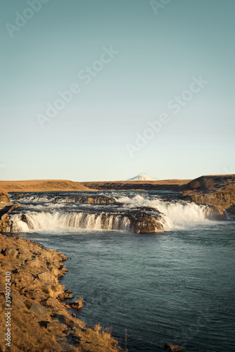 Typical Icelandic scenery with waterfall and volcano