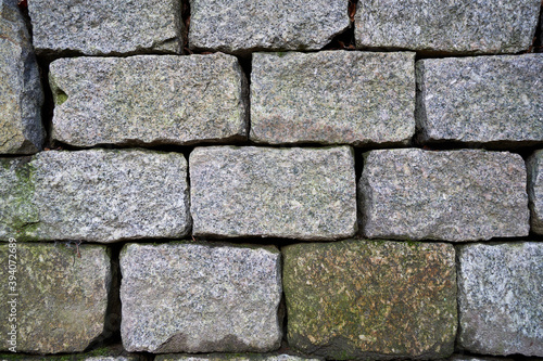 Gray bricks lie on top of each other and form a wall. closeup.