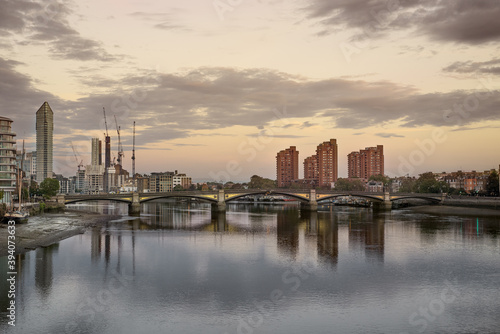 Calm sunrise over the buildings reflecting in the water in Battersea