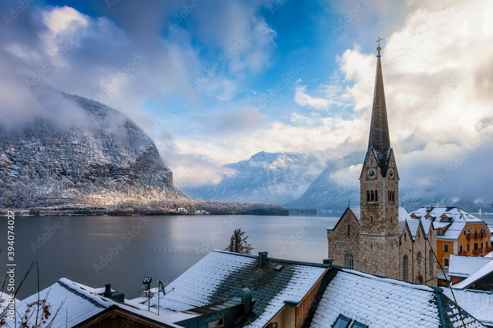 View over the roofs of the little village of Hallstatt, Austria, to the Hallstätter Lake and snow covered mountains of the Alps during winter time