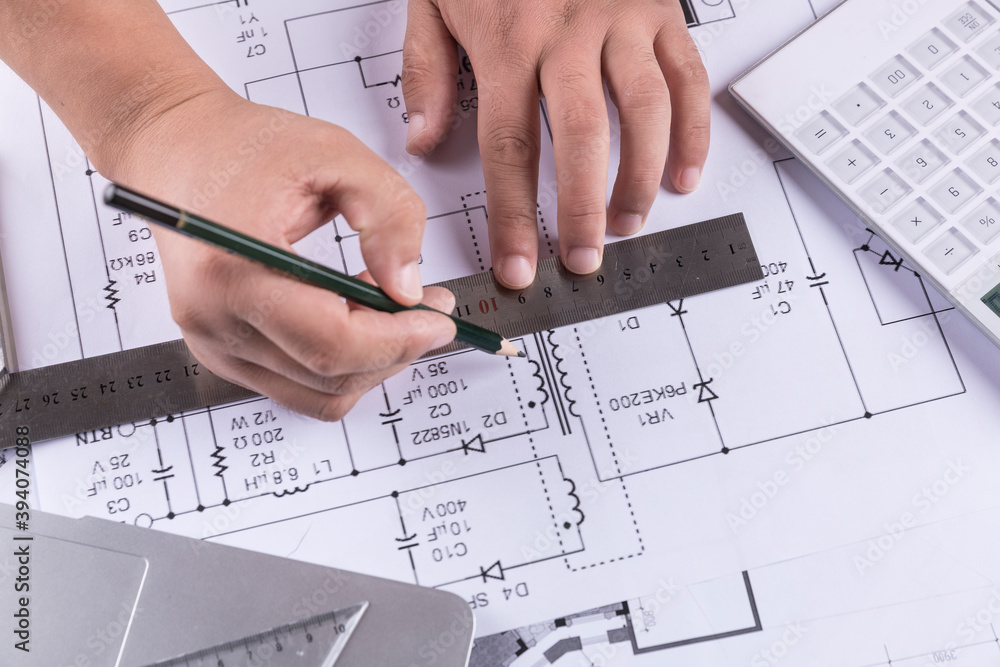 Hand over construction plans with yellow helmet. laptop and drawing tool Hand over construction plans with yellow helmet. laptop and drawing tool