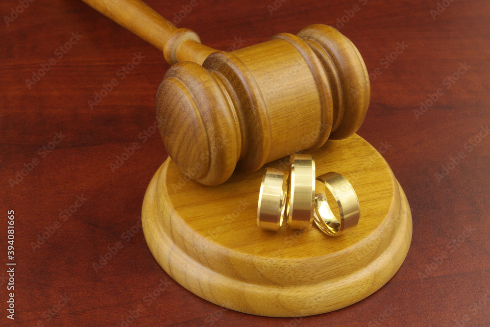 Bigamy concept, two wives wedding ring and one husband ring with judge gavel. Bigamy concept, two wives wedding ring and one husband ring with judge gavel.