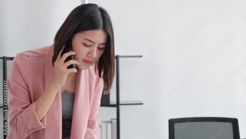 Asian freelance business woman working while working on laptop in living room at office . girl sitting on desk work overtime, enjoy relax time.female working stress and problem . Asian freelance business woman working while working on laptop in living room at office . girl sitting on desk work overtime, enjoy relax time.female working stress and problem .