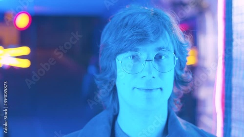 Close up portrait of hipster in the neon light of the nightclub. Evening city life.