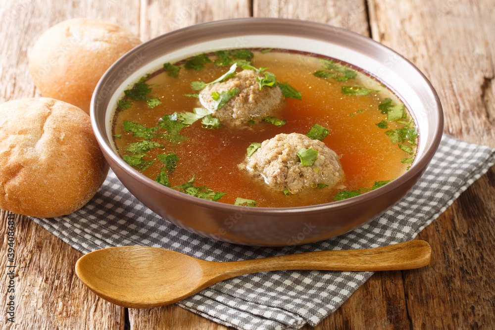 liver dumpling soup made of beef liver, bread, eggs, and parsley cooked in beef broth close up in a dish. horizontal