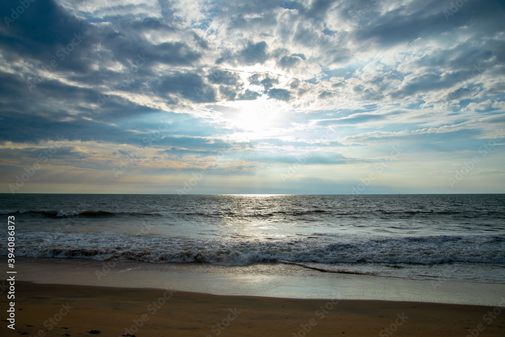 Blue ocean beach sunset with blue cloudy sky and sun rays. Blue ocean beach sunset with blue cloudy sky and sun rays.