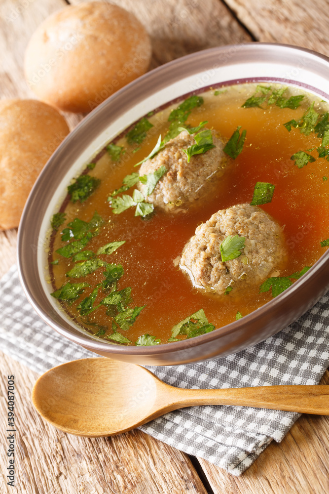 Leberknodelsuppe German liver dumpling soup close-up in a saucepan on the table. Vertical Leberknodelsuppe German liver dumpling soup close-up in a saucepan on the table. Vertical