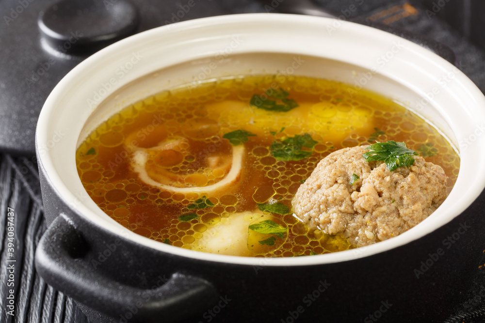 Beef broth or Rindsuppe is the most popular of Austria’s with pancake strips Frittaten, semolina dumplings, liver dumpling close-up in a saucepan on the table. horizontal Beef broth or Rindsuppe is the most popular of Austria’s with pancake strips Frittaten, semolina dumplings, liver dumpling close-up in a saucepan on the table. horizontal
