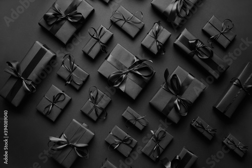 Elegant black Christmas theme. Wrapped gifts in black matte paper with ribbon