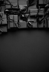 A pile various size black boxed gifts placed on stack. Christmas concept.