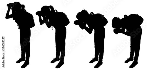 Tourist with a backpack and binoculars. The girl bends down to see the object in her binoculars. A group of women. Ornithologists. The four black female silhouettes are isolated on a white background.
