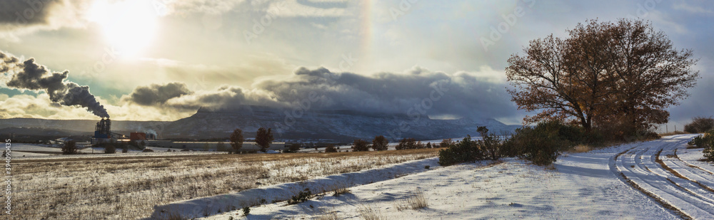 Panoramic of snowy landscape with factory and a path