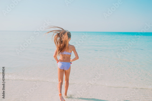 Adorable active little girl at beach during summer vacation