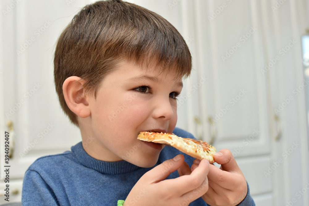 Happy boy eats pizza. Child eating pizza, ordering fast food for dinner