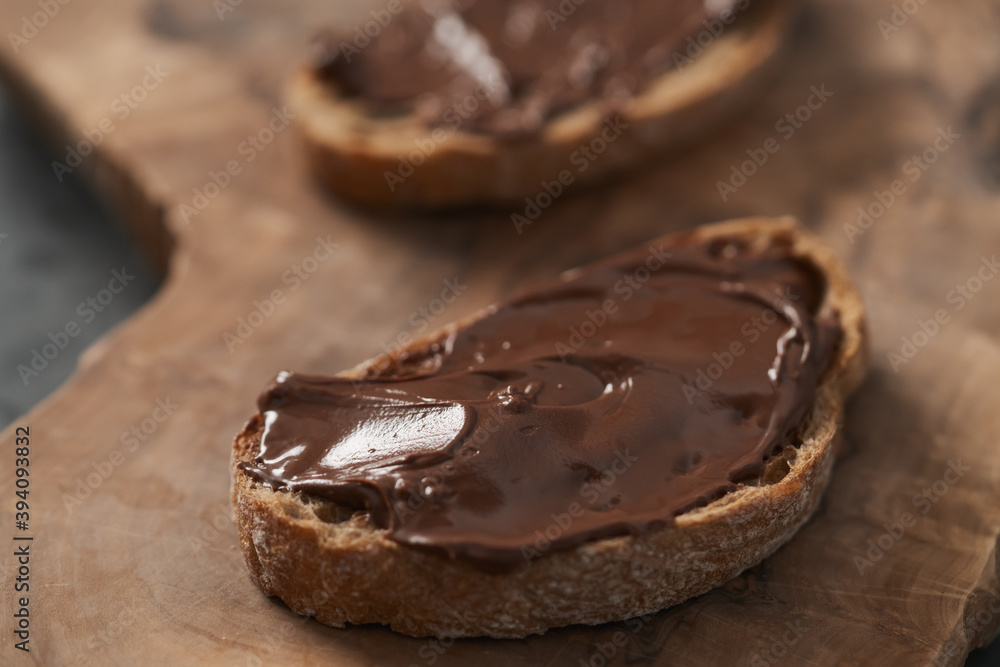 Ciabatta slices with chocolate spread on olive wood board Ciabatta slices with chocolate spread on olive wood board