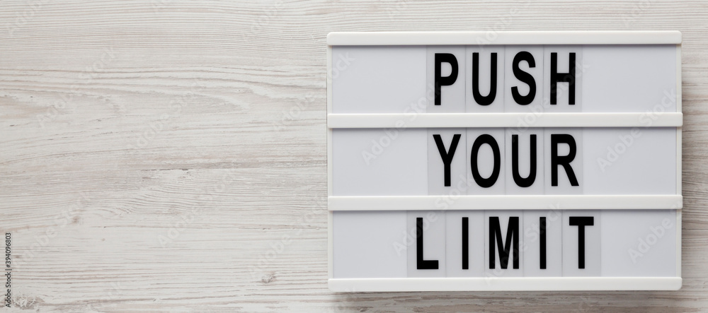 'Push your limit' words on a lightbox on a white wooden surface, top view. Overhead, from above, flat lay. Copy space. 'Push your limit' words on a lightbox on a white wooden surface, top view. Overhead, from above, flat lay. Copy space.