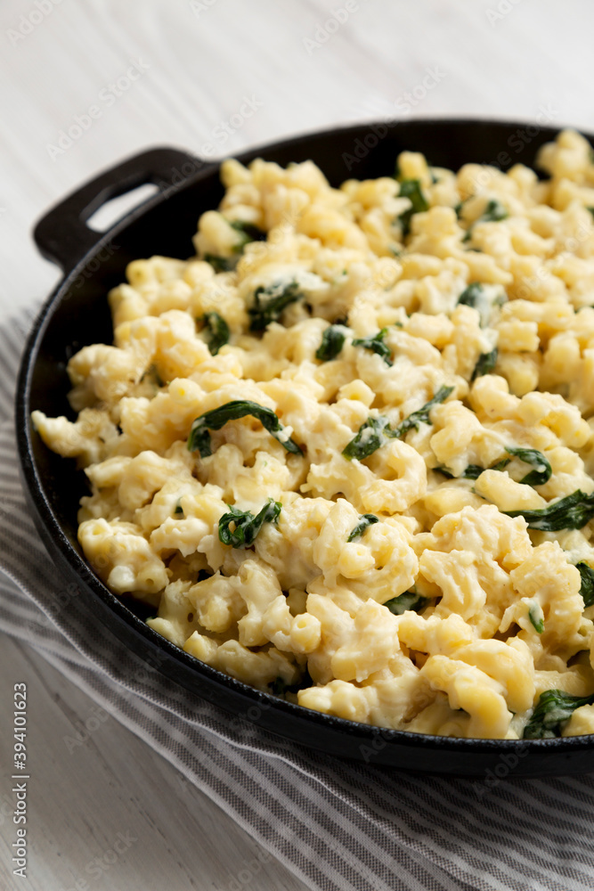 Homemade Spinach Mac and Cheese in a cast-iron pan, side view. Close-up. Homemade Spinach Mac and Cheese in a cast-iron pan, side view. Close-up.