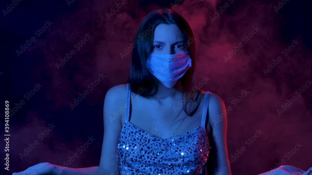 Portrait of charming young woman in a medical mask, she looks around in confusion and shows a gesture with his hands I dont know. Close up. Slow motion. Portrait of charming young woman in a medical mask, she looks around in confusion and shows a gesture with his hands I dont know. Close up. Slow motion.