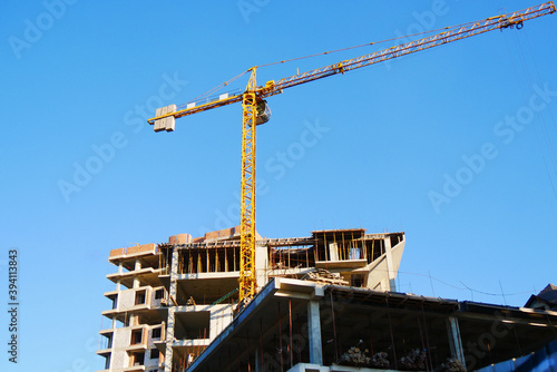Construction site backgroun.d. Hosting crane near multi-storey building. Industrial background.